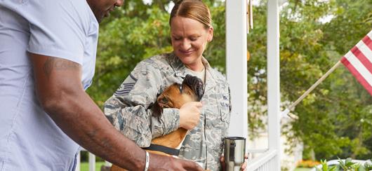 Woman In Fatigues On Porch With Husband And Dog