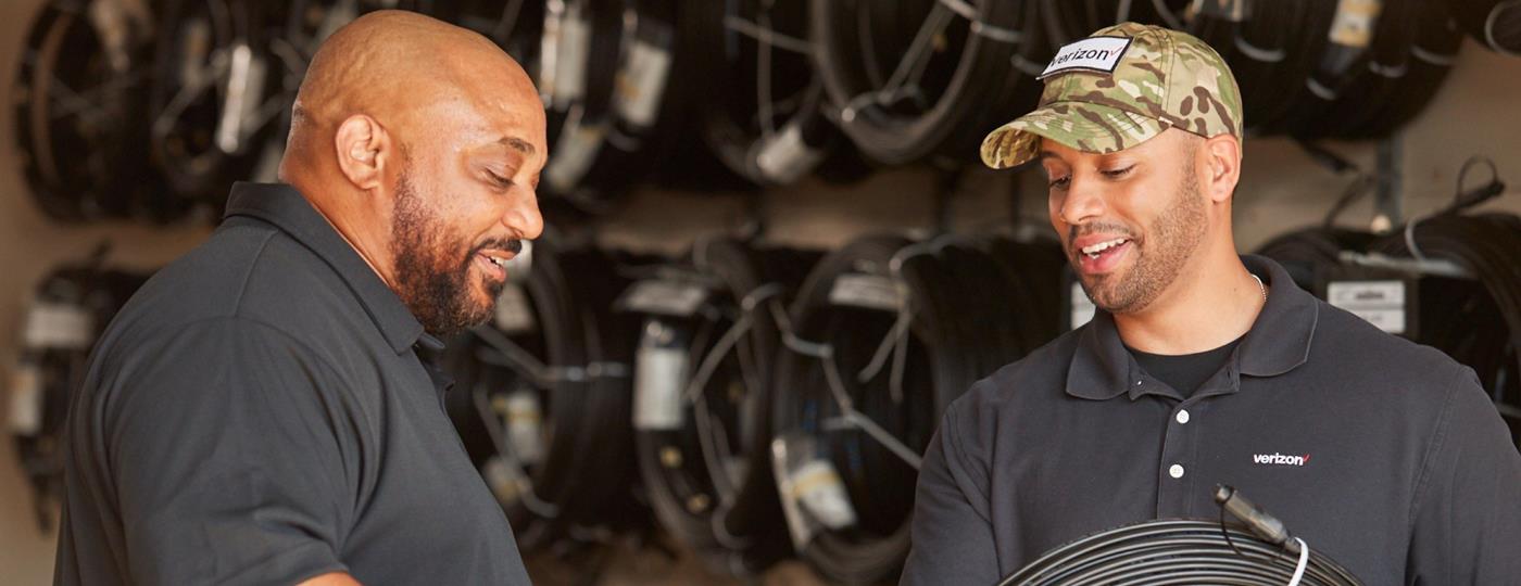 Two Verizon Technicians Talking In A Garage