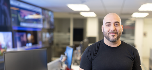 Bald Man Wearing A Verizon Tshirt Working In The Office (1)
