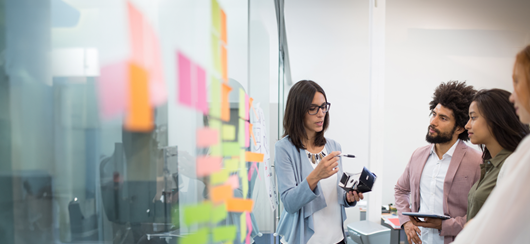 Woman Showing Off New Product Prototype To Team