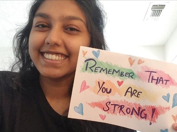 Young Woman Holding A Sign That Reads You Are Strong
