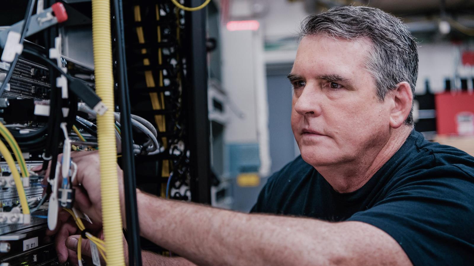 Close Up Of A Man Doing Some Wiring In A Server Room