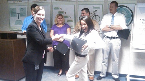 Jennifer shaking hands at her New Hire Graduation Ceremony