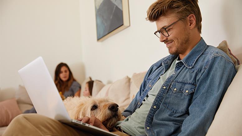 Man with dog and laptop on his lap